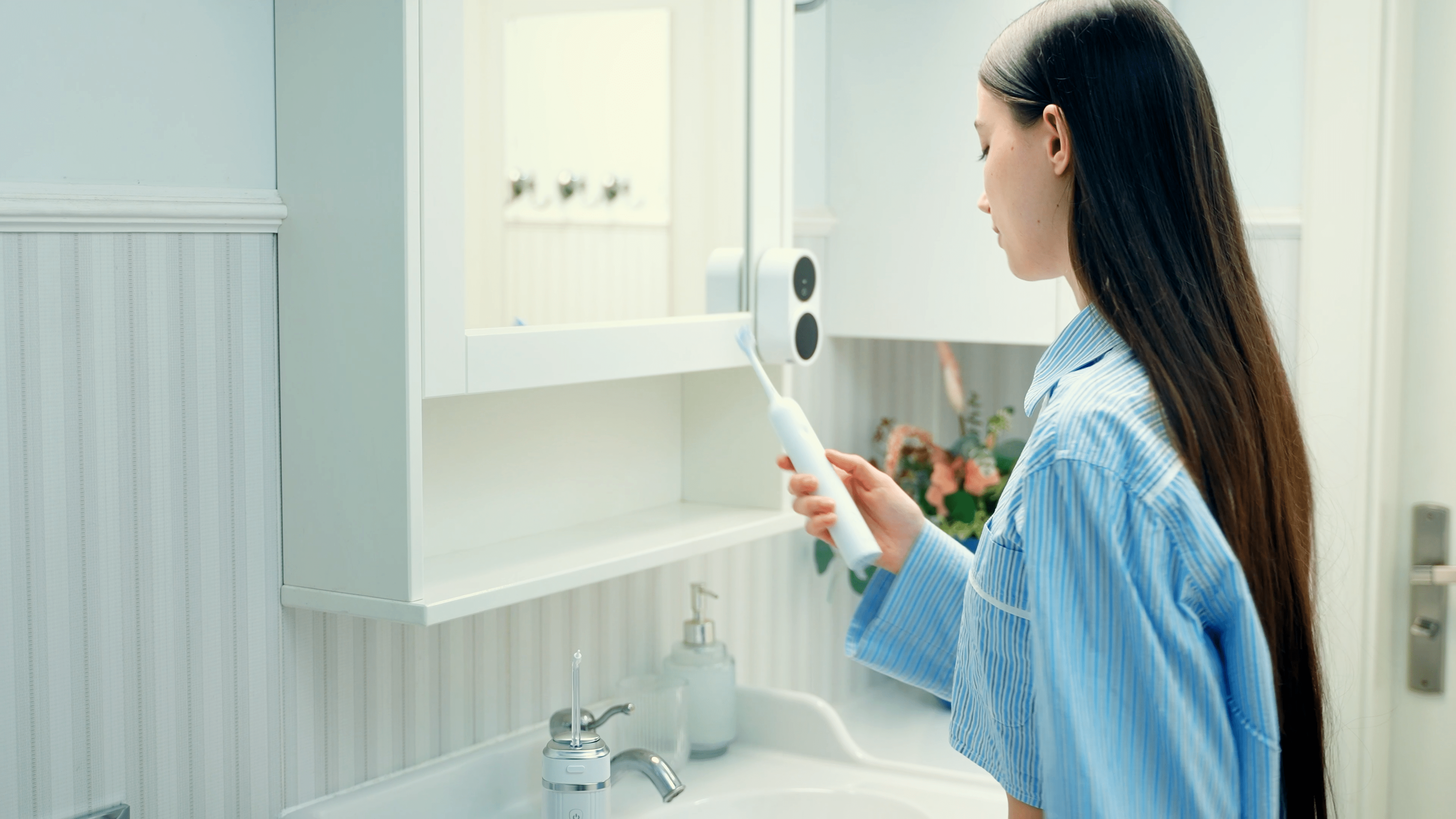 ZENT® SoniQ™ – Aktywna szczoteczka soniczna z ruchem oscylacyjnym 40° trzymana w ręku przez kobietę ubraną w niebieską piżamę